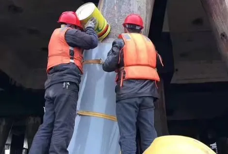 Underwater adhesive application on coastal bridge pier fiberglass sleeve